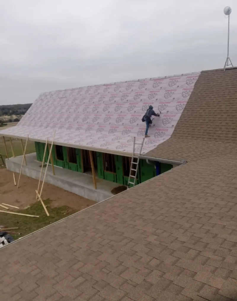 Worker preparing underlayment for a metal roof installation in Paradise